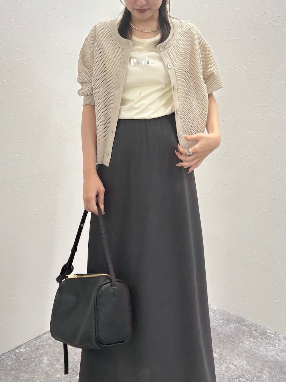 ベージュ系のカーディガン/ボレロ、ホワイト系のTシャツ/カットソー、グレー系のスカートを着用したレディースの秋コーディネートの2枚目の写真