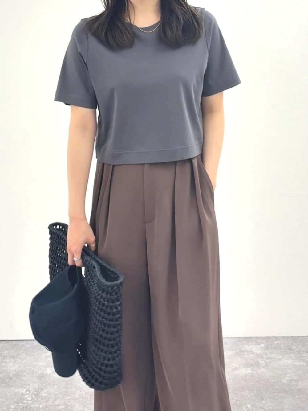 グレー系のTシャツ/カットソー、ブラウン系のその他パンツ、ブラック系のかごバッグを着用したレディースの春コーディネートの7枚目の写真