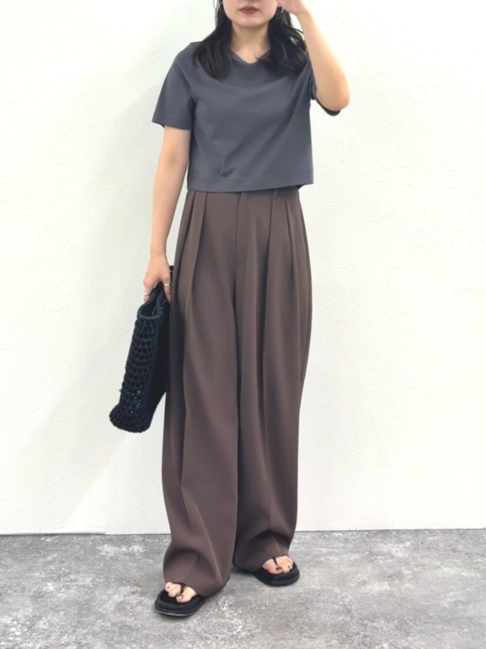 グレー系のTシャツ/カットソー、ブラウン系のその他パンツ、ブラック系のかごバッグを着用したレディースの春コーディネートの8枚目の写真