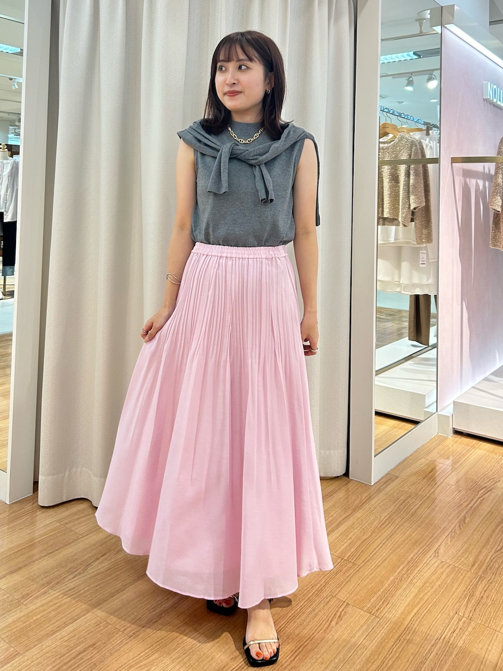 ピンク系のスカート、グレー系のカーディガン/ボレロ、グレー系のニット/セーターを着用したレディースの夏コーディネートの3枚目の写真