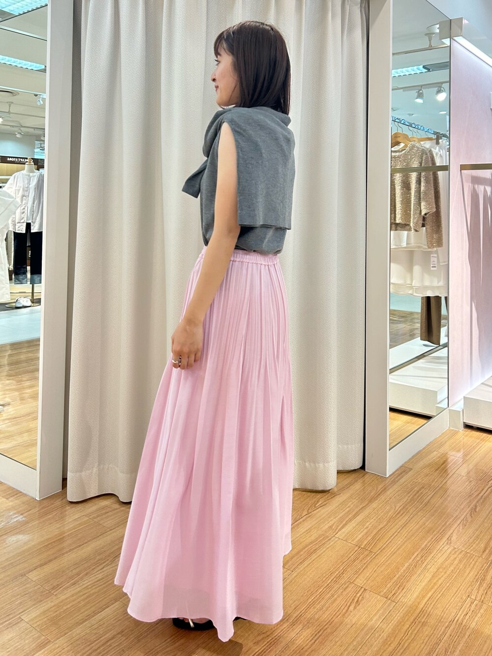 ピンク系のスカート、グレー系のカーディガン/ボレロ、グレー系のニット/セーターを着用したレディースの夏コーディネートの6枚目の写真