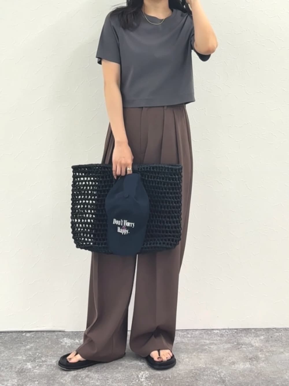 グレー系のTシャツ/カットソー、ブラウン系のその他パンツ、ブラック系のかごバッグを着用したレディースの春コーディネートの5枚目の写真
