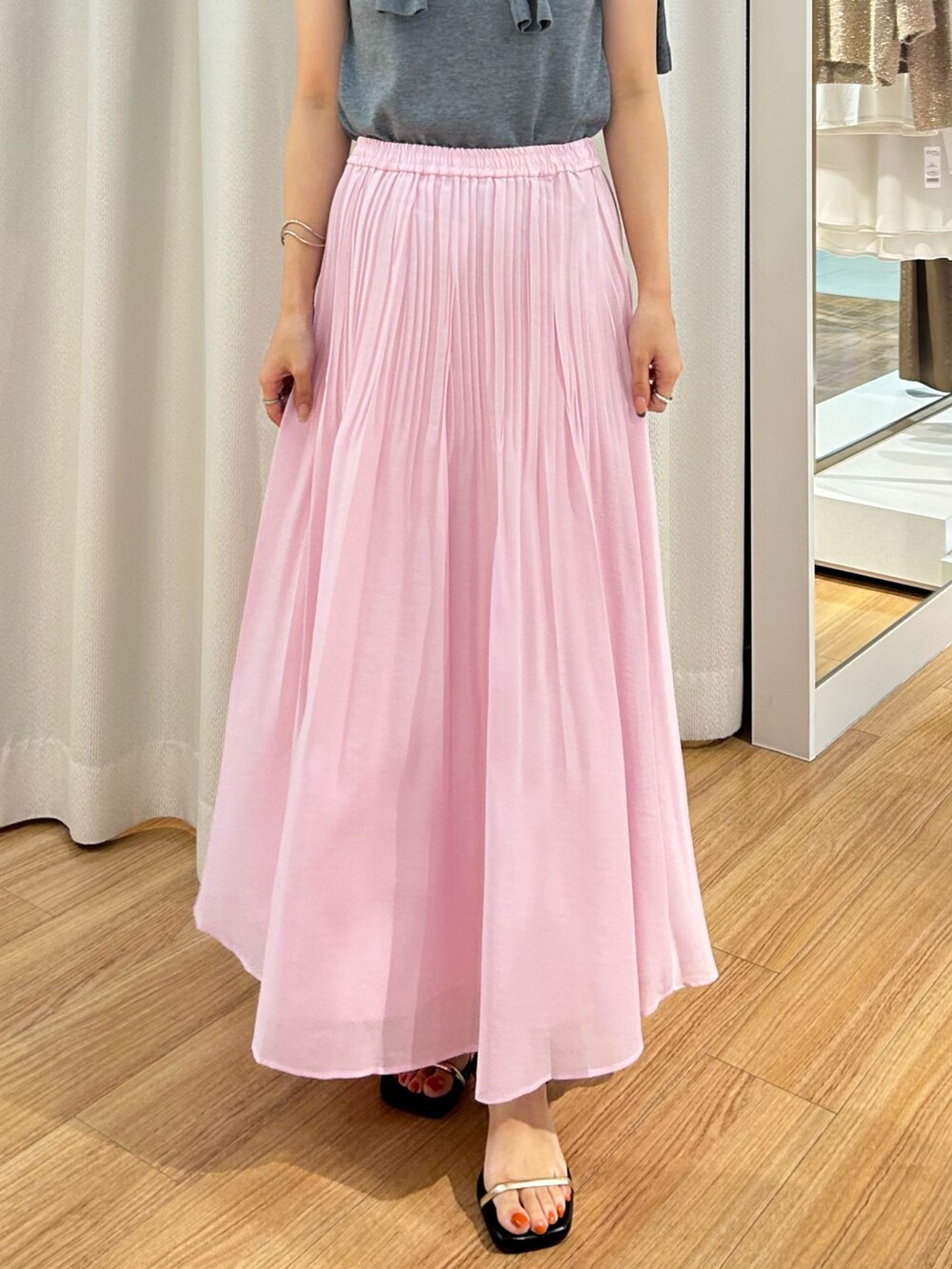 ピンク系のスカート、グレー系のカーディガン/ボレロ、グレー系のニット/セーターを着用したレディースの夏コーディネートの4枚目の写真