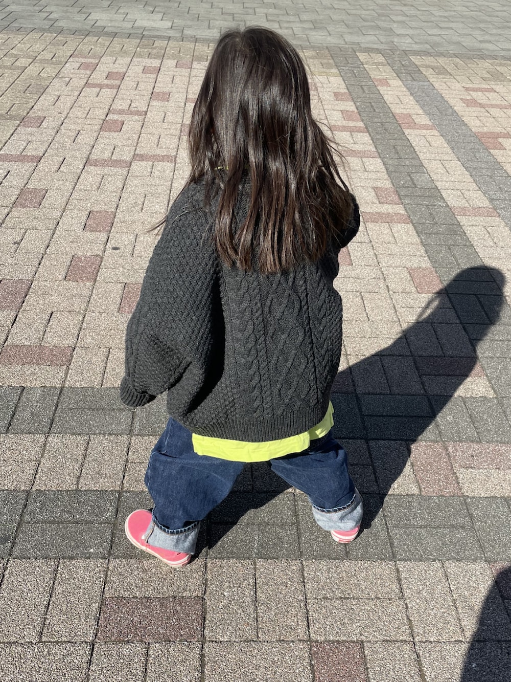 グレー系のカーディガン/ボレロ、ブルー系のデニムパンツ、グリーン系のTシャツ/カットソーを着用したキッズの冬コーディネートの2枚目の写真