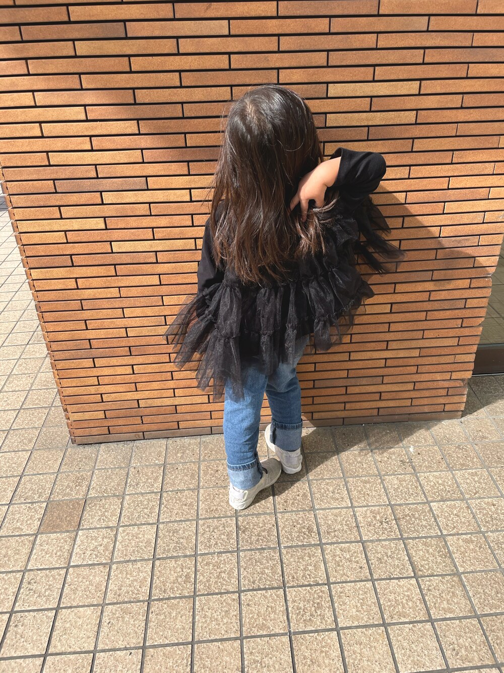 ブラック系のTシャツ/カットソー、ホワイト系のサンダルを着用したキッズの秋コーディネートの2枚目の写真