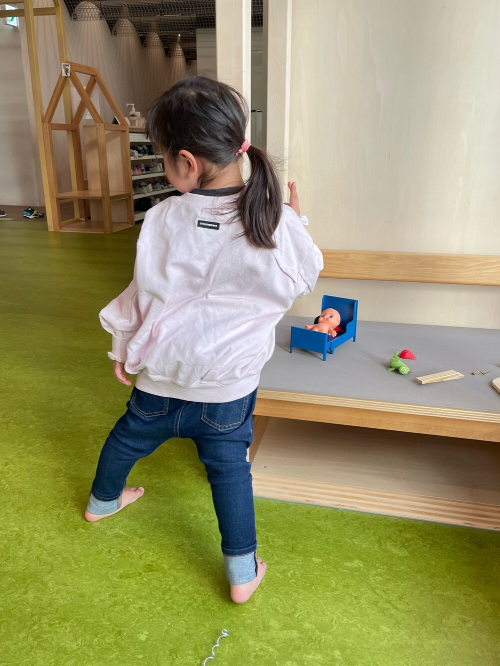 ピンク系のスウェット、ブルー系のデニムパンツを着用したキッズの冬コーディネートの2枚目の写真
