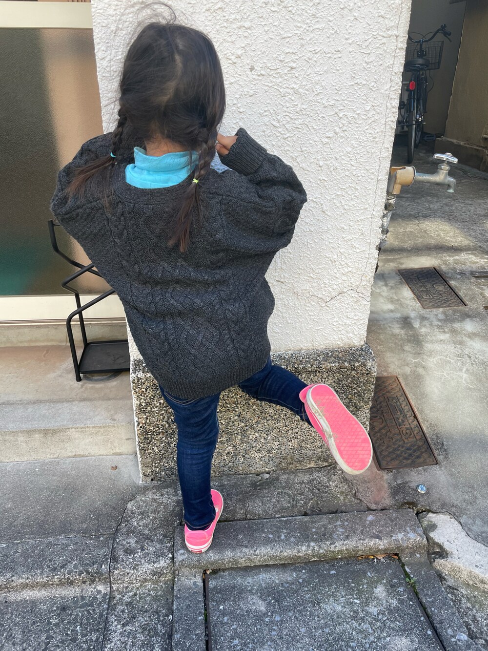 グレー系のカーディガン/ボレロ、ブルー系のデニムパンツ、ピンク系のスニーカーを着用したキッズの冬コーディネートの2枚目の写真