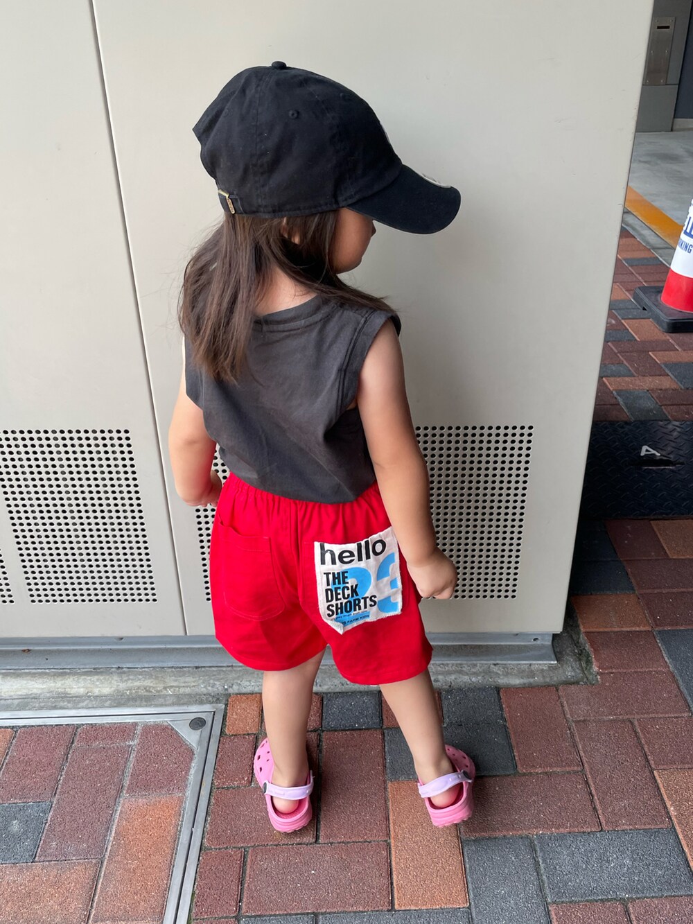 レッド系のその他パンツ、グレー系のTシャツ/カットソー、ブラック系のキャップを着用したキッズの夏コーディネートの3枚目の写真
