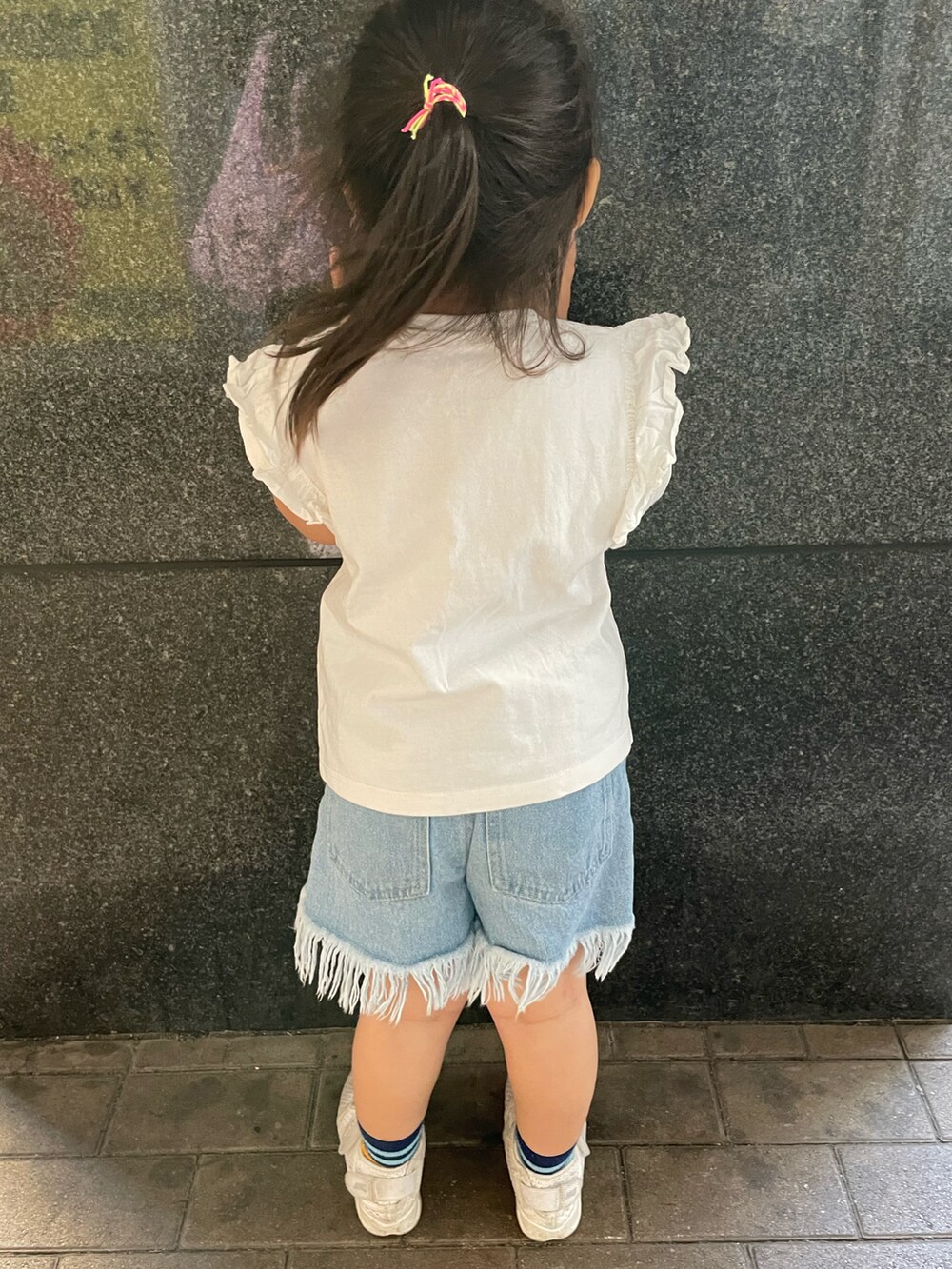 ホワイト系のTシャツ/カットソー、ブルー系のデニムパンツ、ホワイト系のスニーカーを着用したキッズの春コーディネートの4枚目の写真