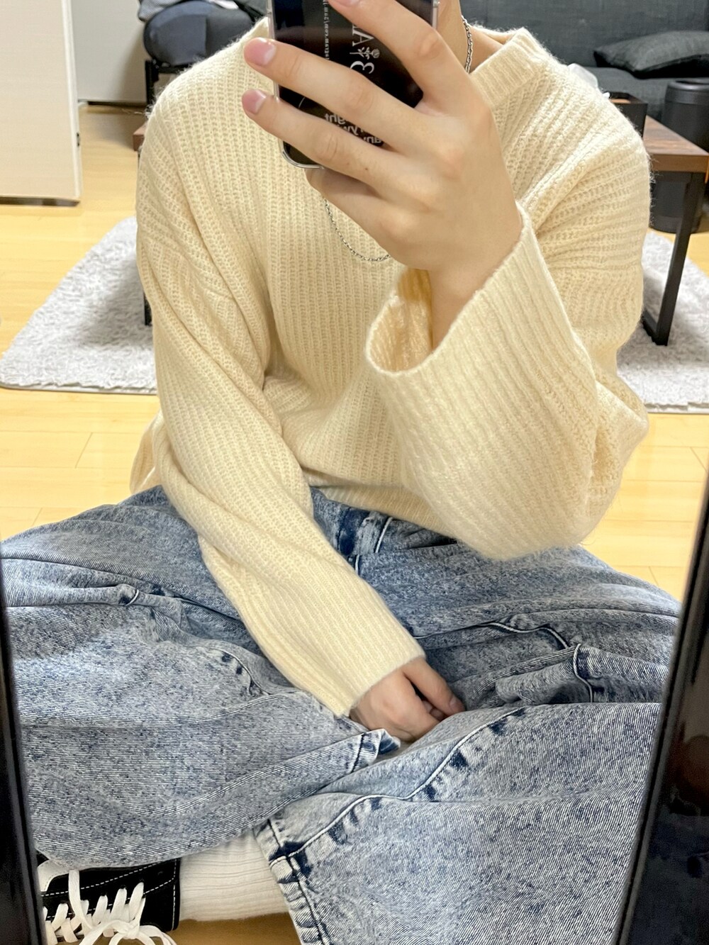 ホワイト系のニット/セーター、ブルー系のデニムパンツ、ブラック系のスニーカーを着用したメンズの秋コーディネートの2枚目の写真