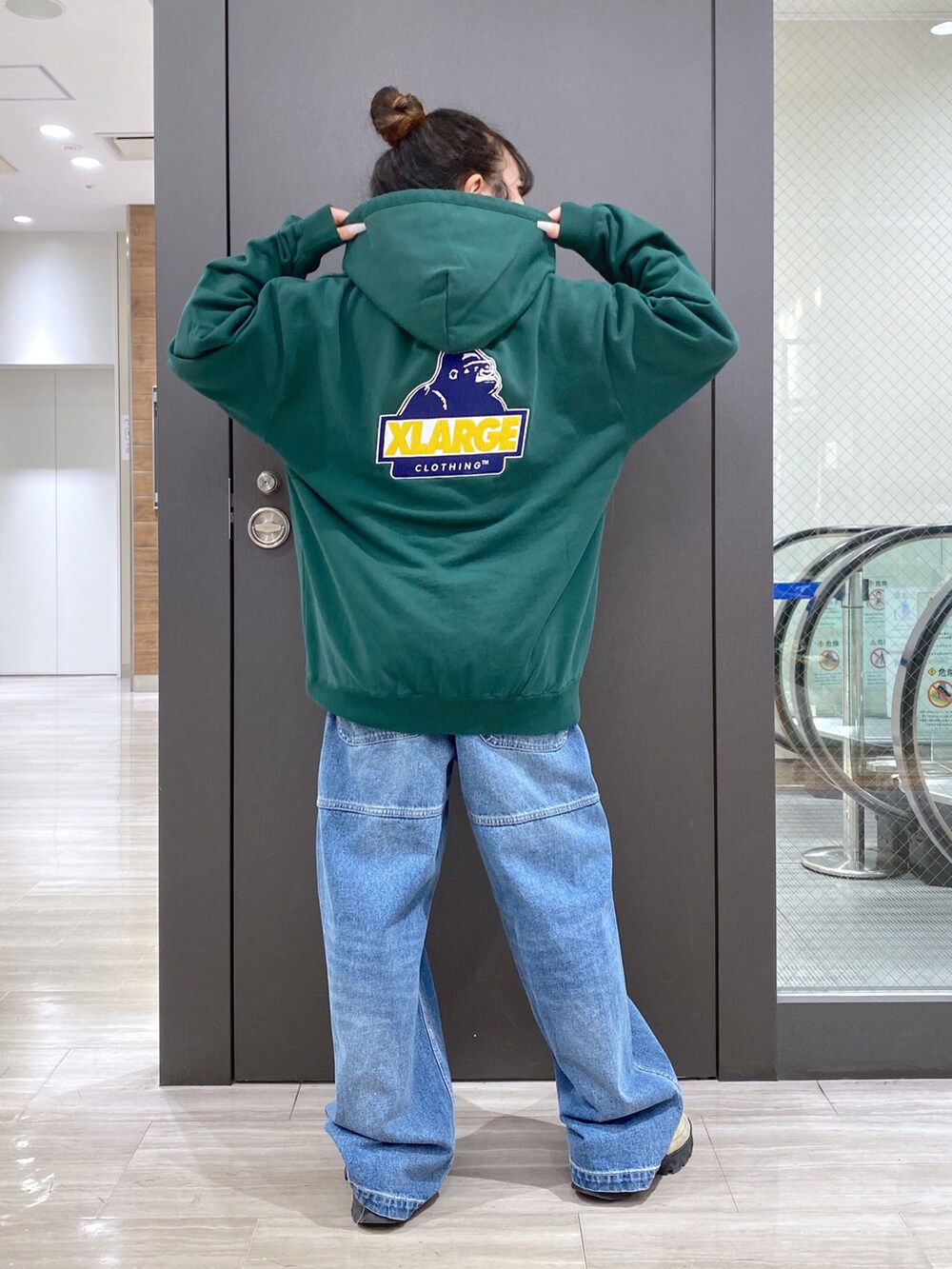 グリーン系のパーカー、ブルー系のその他パンツ、ブラック系のバックパック/リュックを着用したレディースの冬コーディネートの4枚目の写真