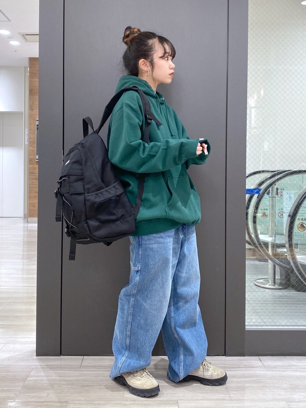 グリーン系のパーカー、ブルー系のその他パンツ、ブラック系のバックパック/リュックを着用したレディースの冬コーディネートの2枚目の写真