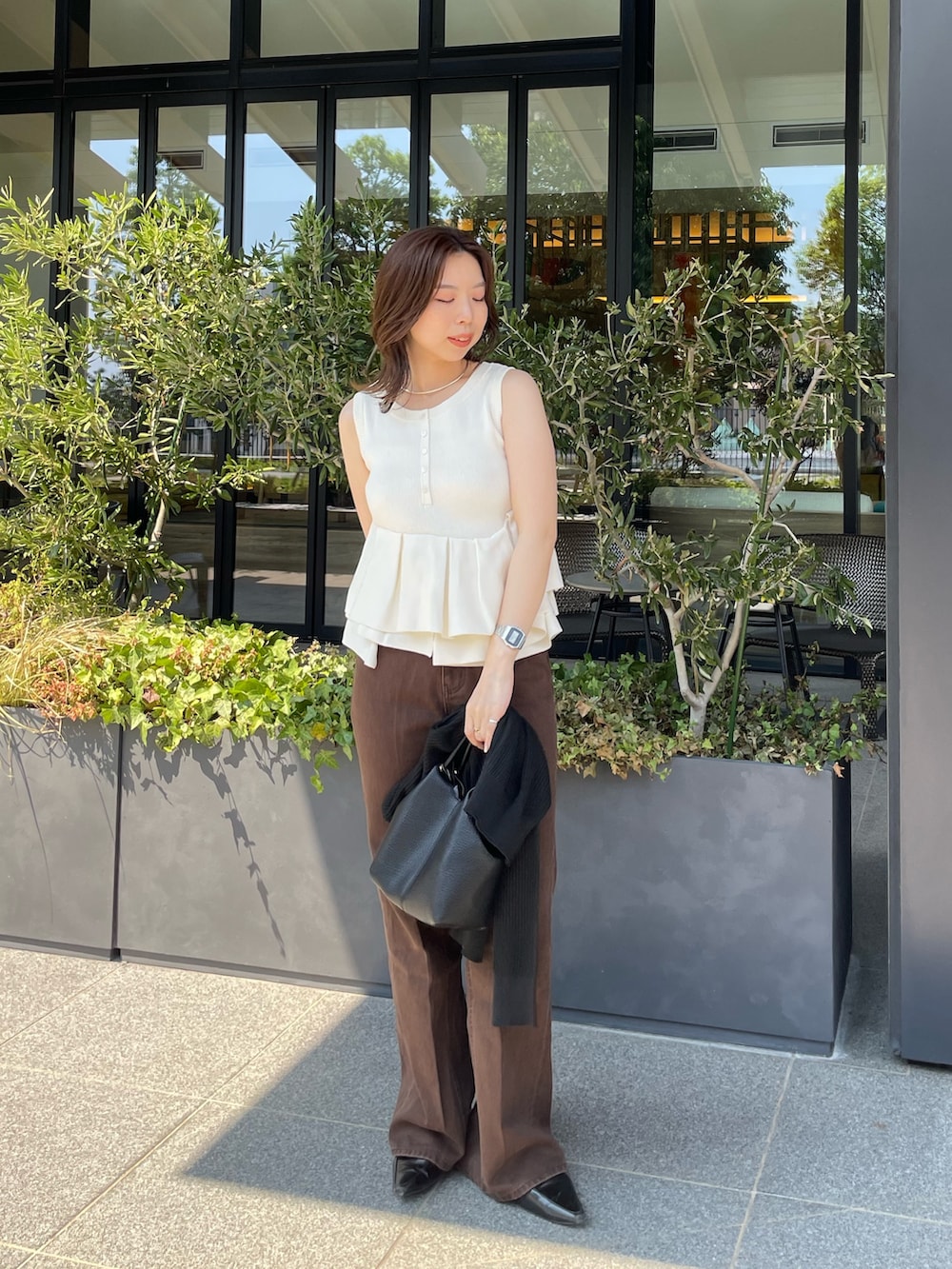 ホワイト系のニット/セーター、ブラウン系のデニムパンツを着用したレディースの夏コーディネートの3枚目の写真