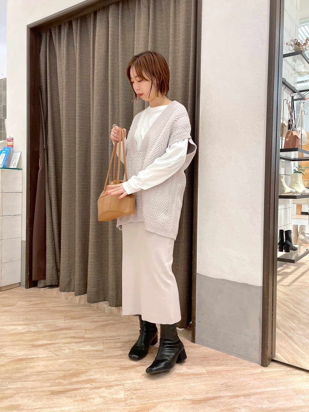 ブラック系のダウンジャケット/コート、ホワイト系のワンピースを着用したレディースの冬コーディネートの2枚目の写真