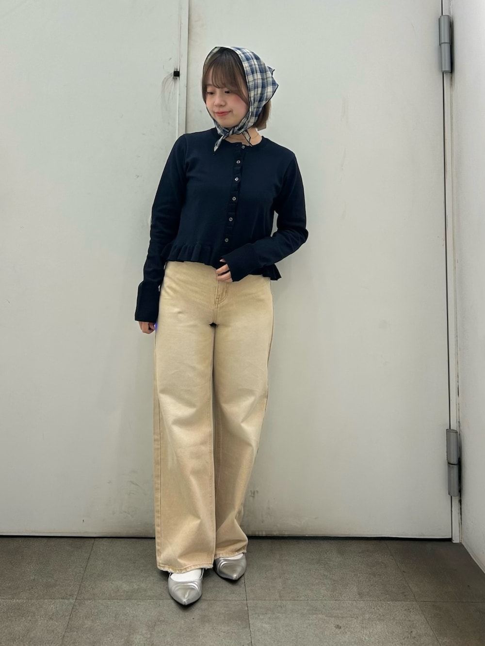 ブルー系のニット/セーター、ベージュ系のデニムパンツ、ブルー系のバンダナ/スカーフを着用したレディースの春コーディネートの2枚目の写真