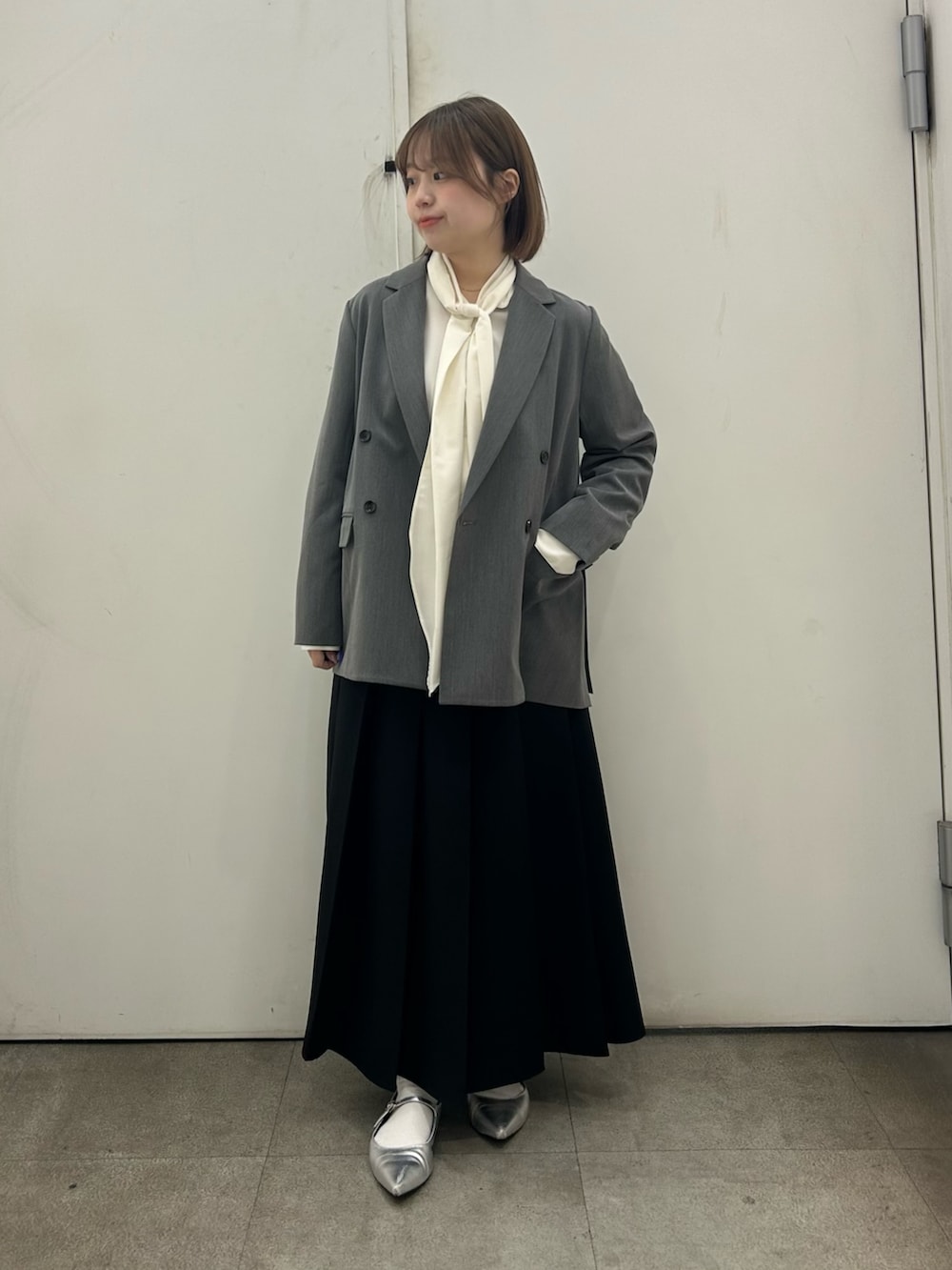 ベージュ系のテーラードジャケット、ホワイト系のシャツ/ブラウス、ブラック系のスカートを着用したレディースの春コーディネートの2枚目の写真