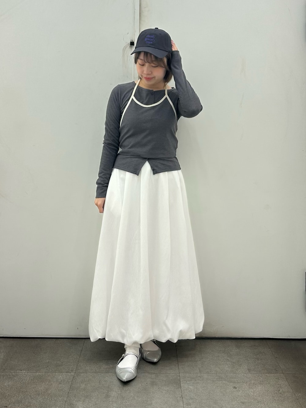 グレー系のTシャツ/カットソー、ホワイト系のスカート、グレー系のキャップを着用したレディースの春コーディネートの2枚目の写真