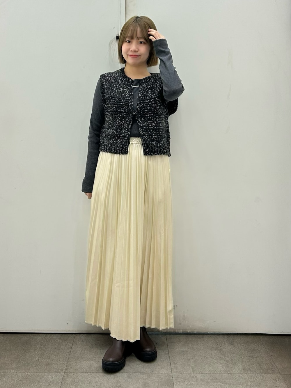 ブラック系のその他アウター、ホワイト系のスカート、グレー系のTシャツ/カットソーを着用したレディースの冬コーディネートの2枚目の写真