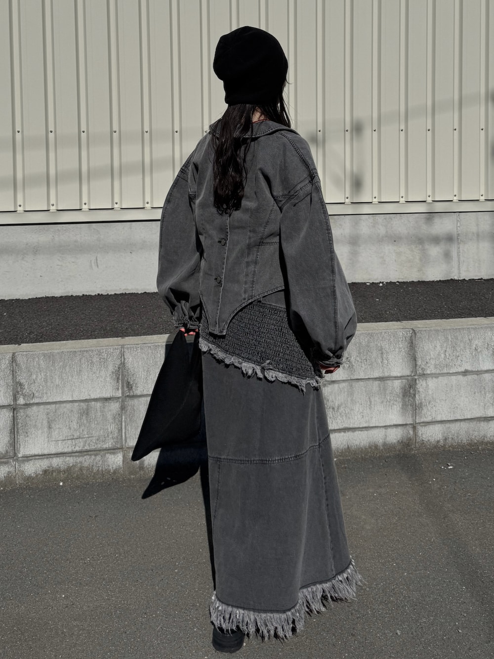 グレー系のデニムジャケット、グレー系のワンピース、ブラック系のブーツを着用したレディースの春コーディネートの3枚目の写真