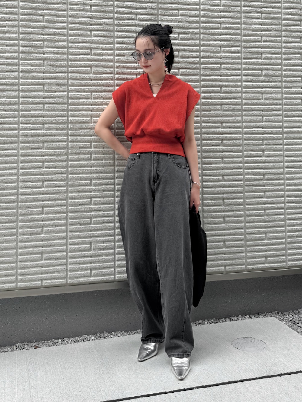 オレンジ系のTシャツ/カットソー、ブラック系のデニムパンツ、ブラック系のハンドバッグを着用したレディースの夏コーディネートの2枚目の写真