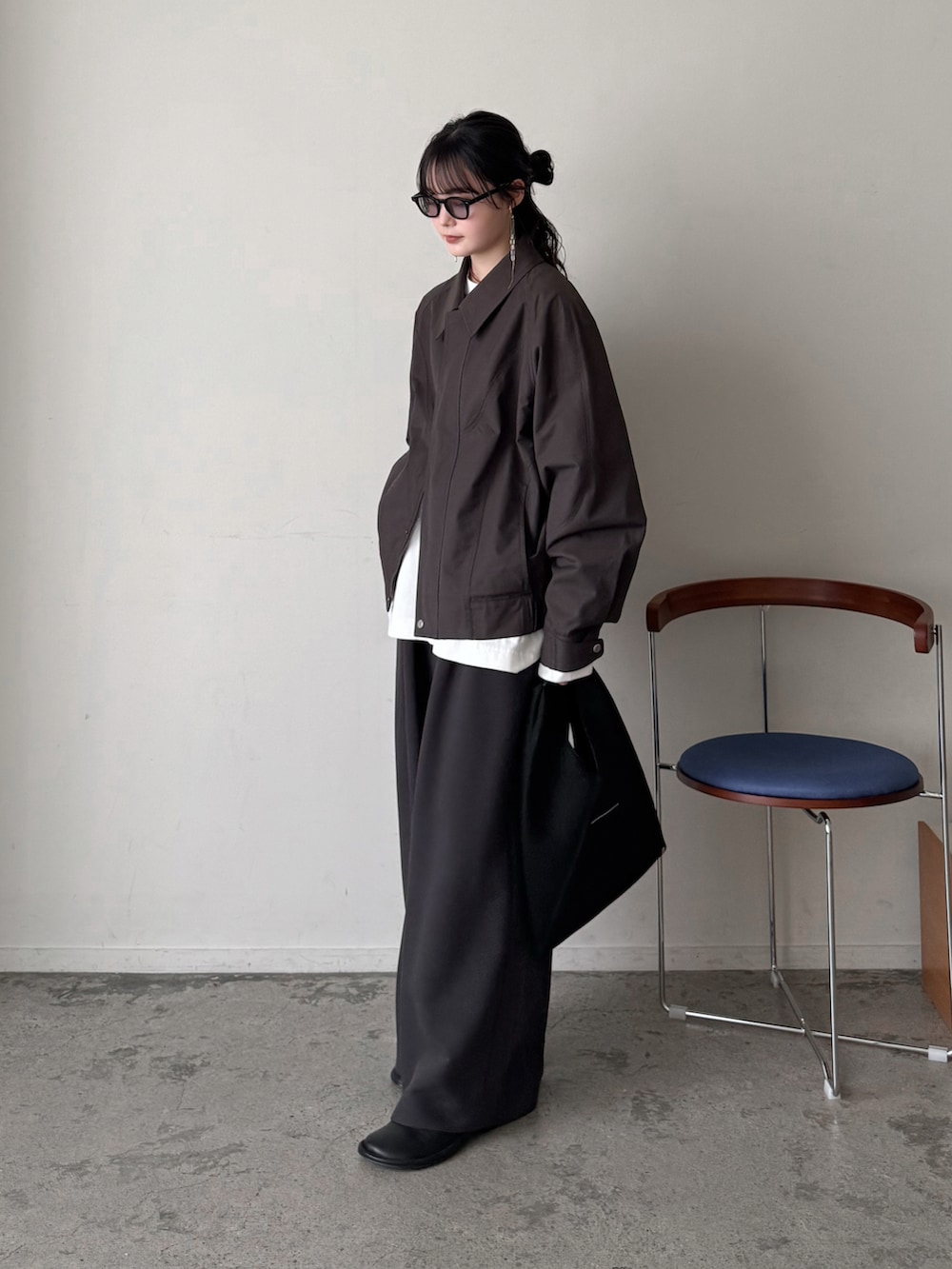 ブラウン系のブルゾン、ホワイト系のTシャツ/カットソー、ブラウン系のスラックスを着用したレディースの春コーディネートの2枚目の写真