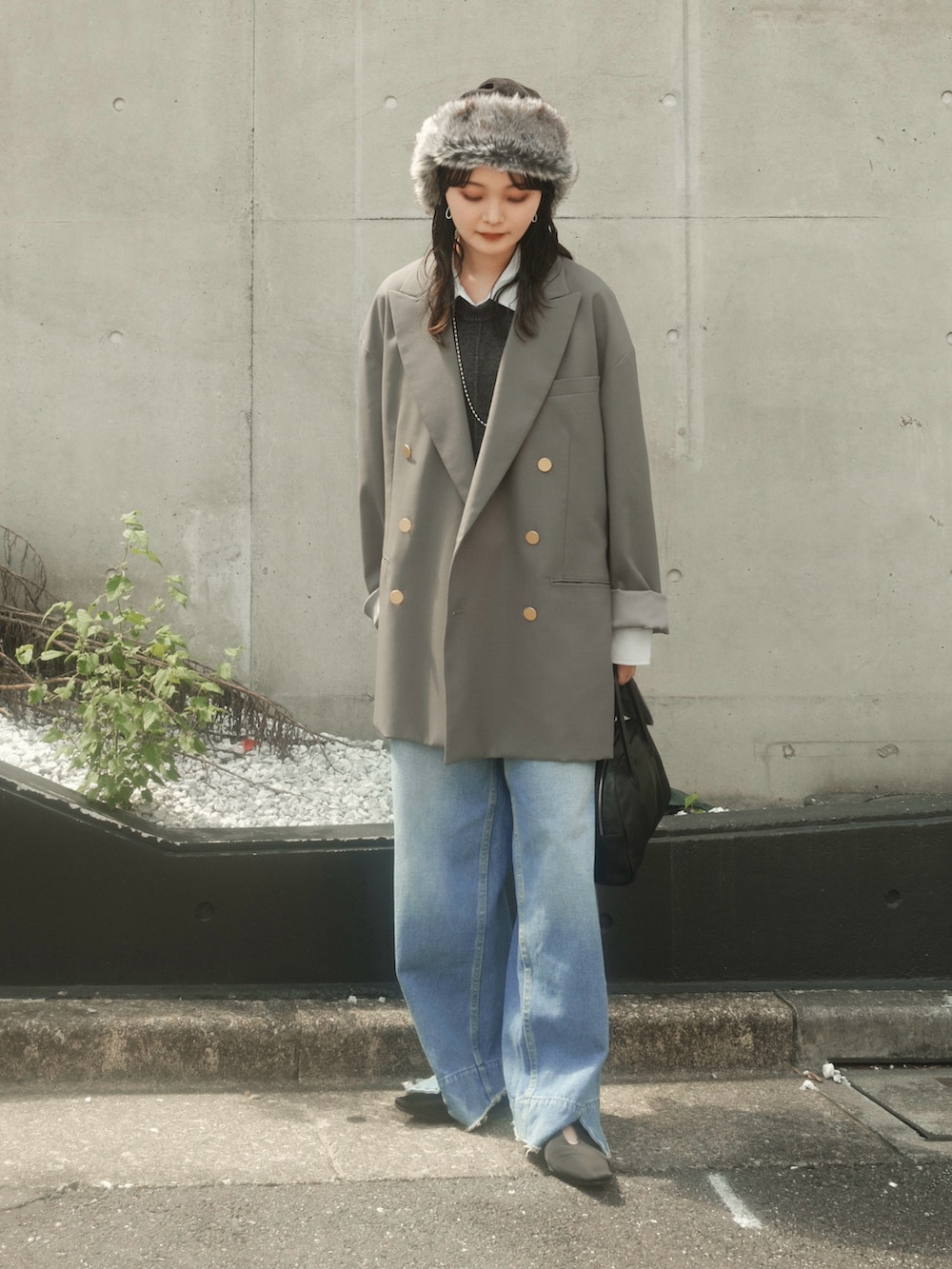 グレー系のテーラードジャケット、グレー系のその他トップス、ブルー系のデニムパンツを着用したレディースの秋コーディネートの2枚目の写真