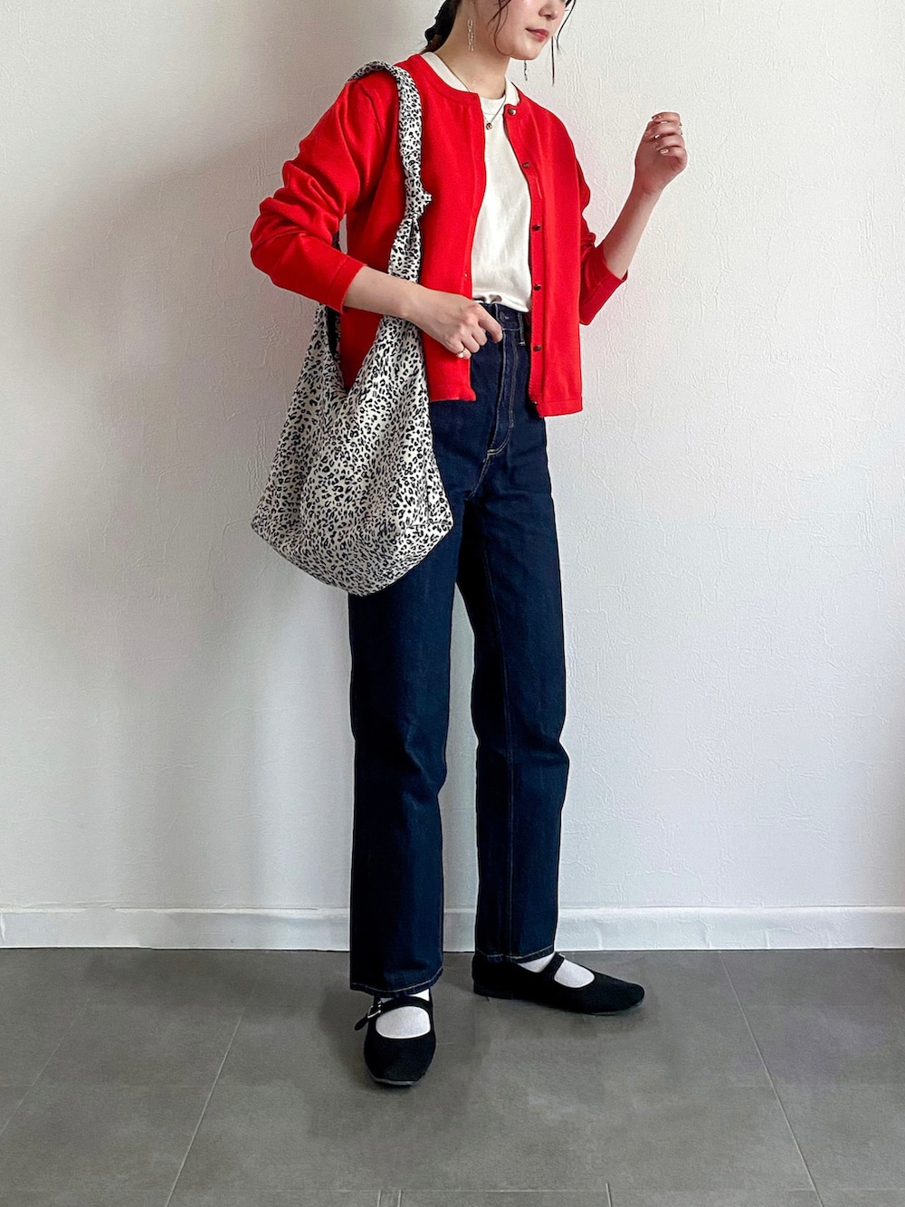 レッド系のカーディガン/ボレロ、ベージュ系のTシャツ/カットソー、ブルー系のパンツを着用したレディースの夏コーディネートの2枚目の写真