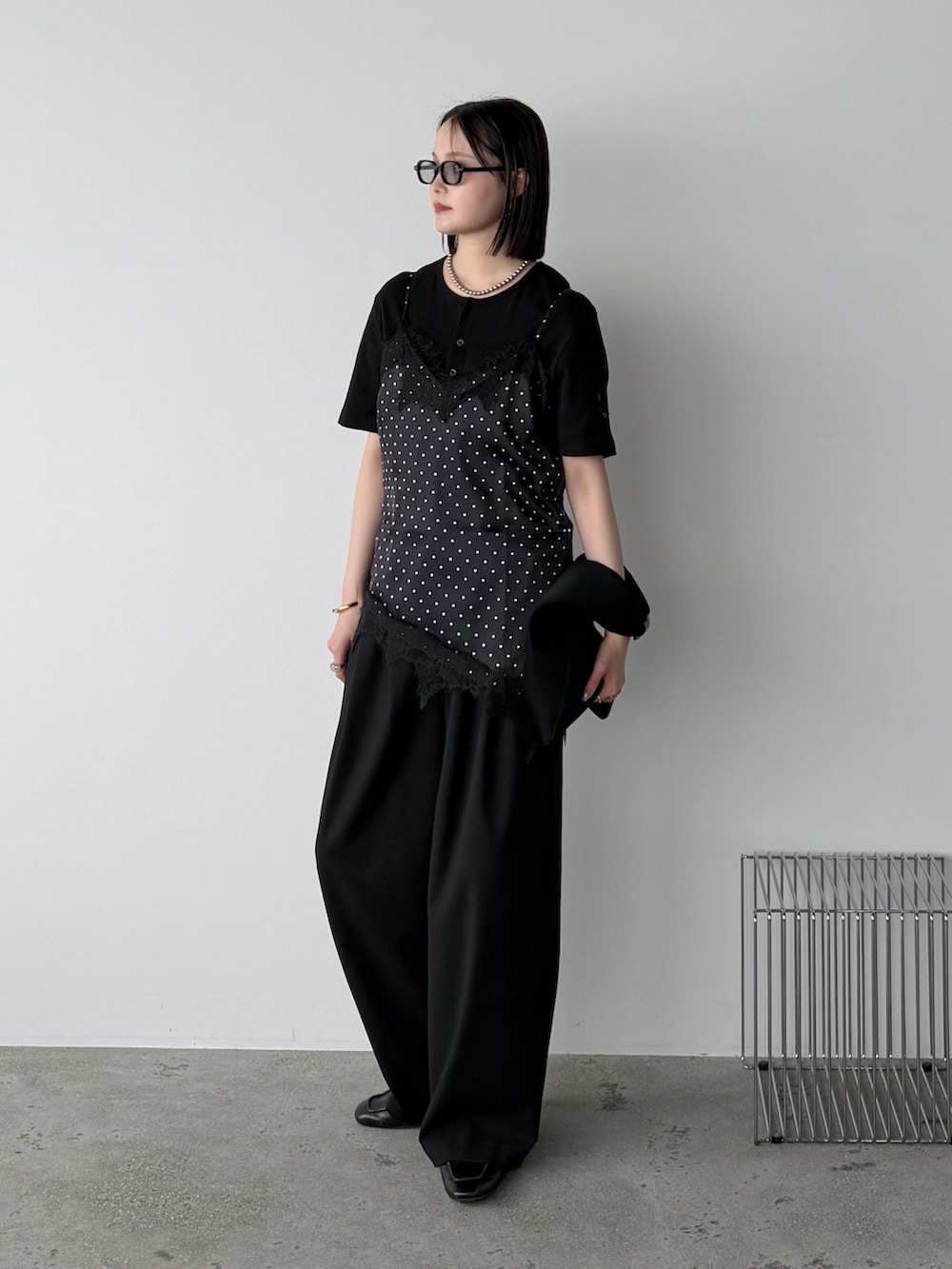 ブラック系のキャミソール、ブラック系のTシャツ/カットソー、ブラック系のスラックスを着用したレディースの夏コーディネートの2枚目の写真
