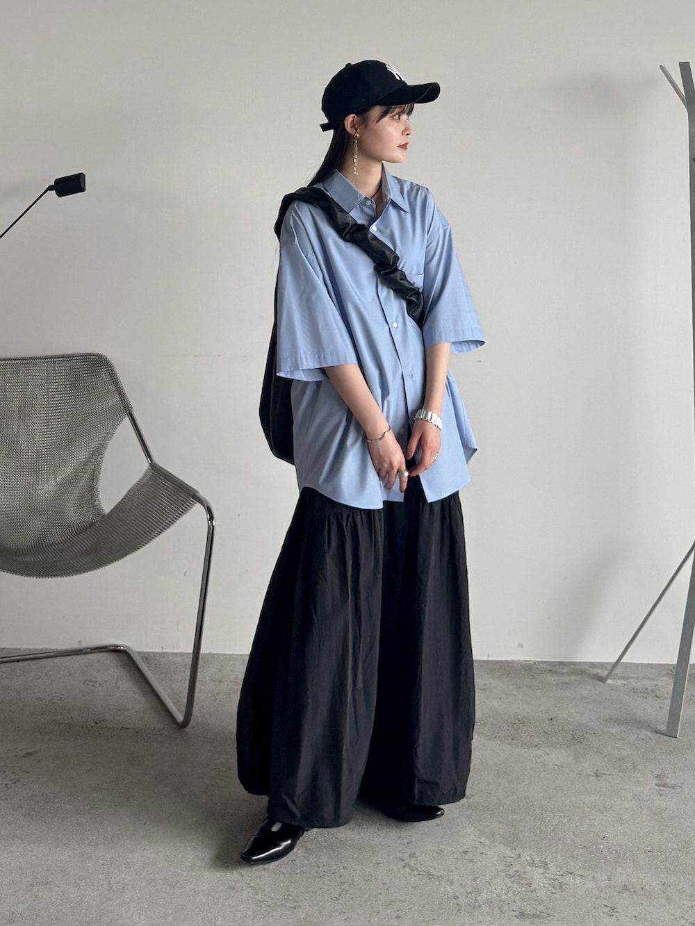 ブルー系のシャツ/ブラウス、ブラック系のスカート、ブラック系のショルダーバッグを着用したレディースの夏コーディネートの2枚目の写真