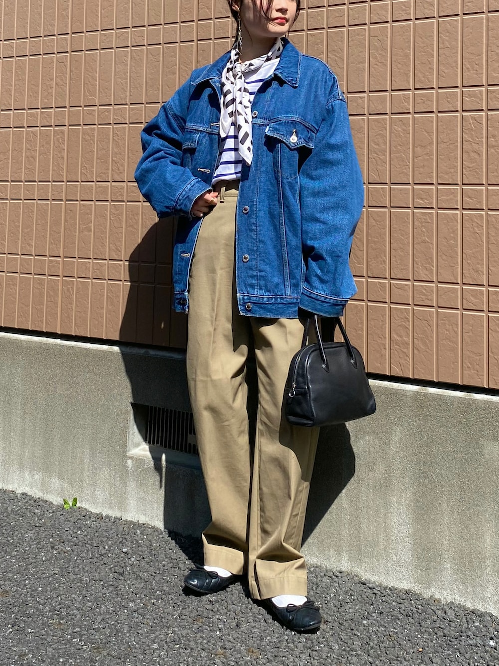 ブルー系のデニムジャケット、ブルー系のTシャツ/カットソー、ベージュ系のチノパンツを着用したレディースの春コーディネートの2枚目の写真