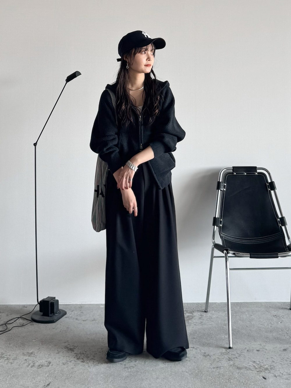 ブラック系のモカシン/デッキシューズ、グレー系のニット/セーター、ブラック系のスラックスを着用したレディースの秋コーディネートの2枚目の写真