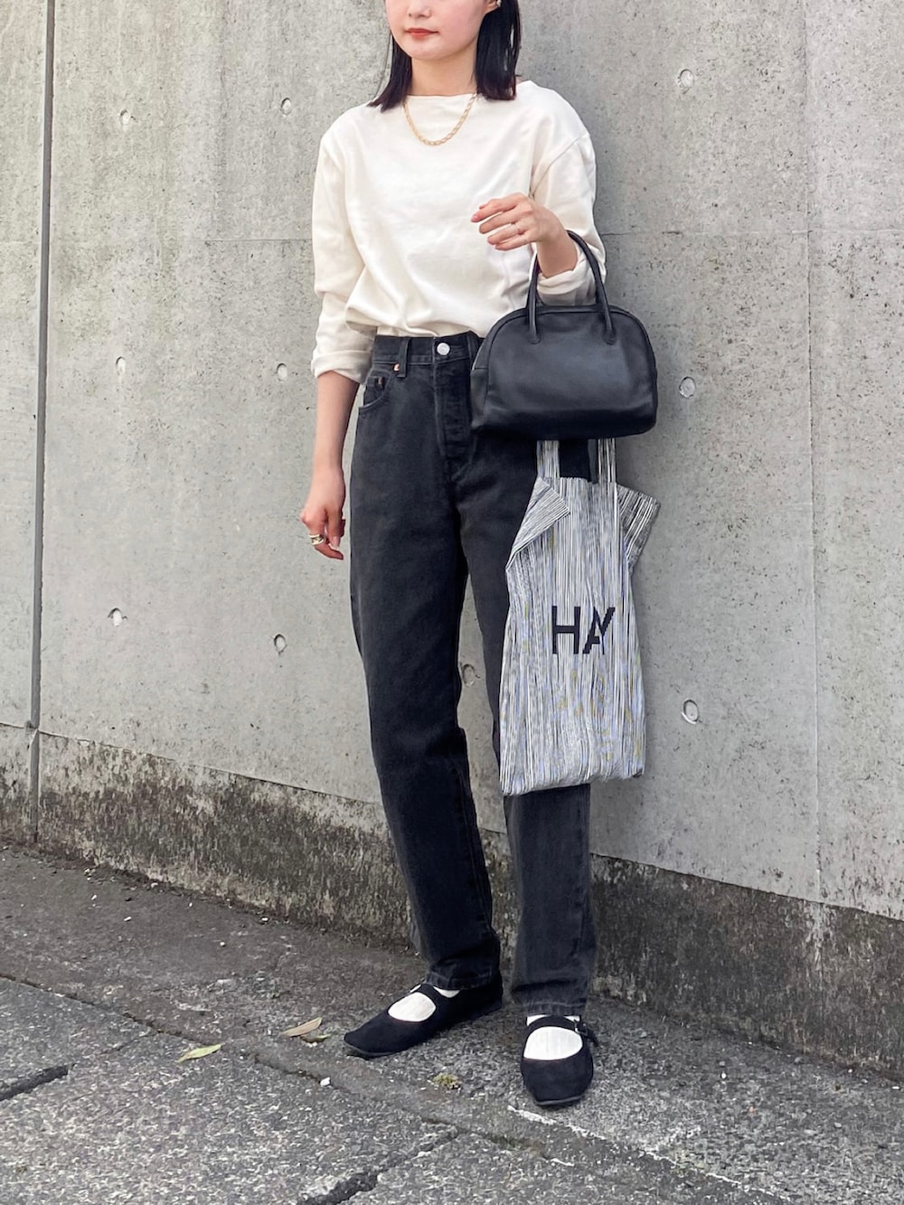 ブラック系のデニムパンツ、ホワイト系のTシャツ/カットソー、ブラック系のショルダーバッグを着用したレディースの夏コーディネートの2枚目の写真