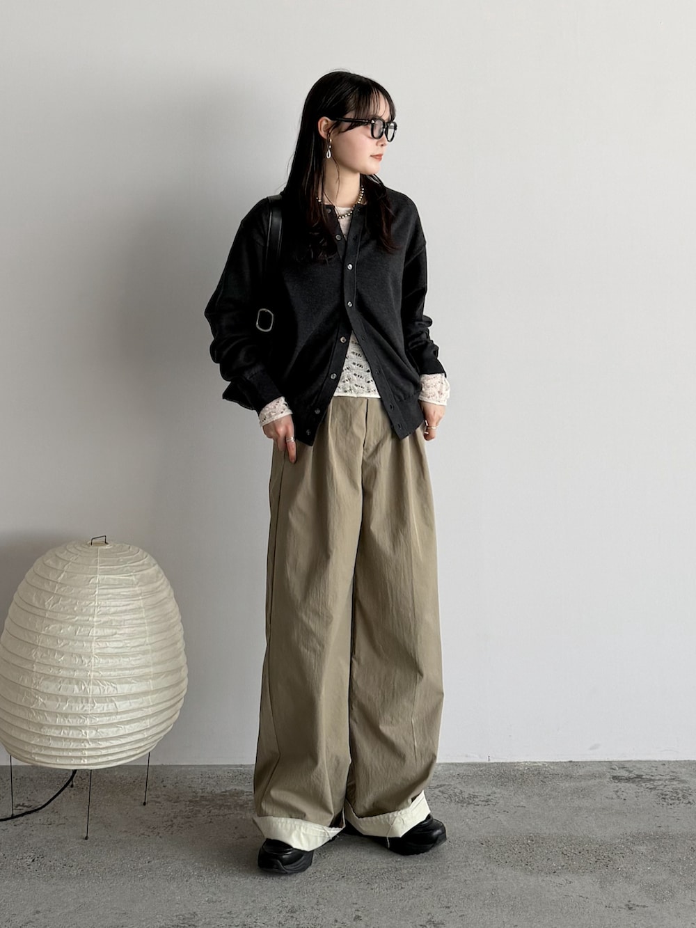 グレー系のカーディガン/ボレロ、ホワイト系のTシャツ/カットソー、ベージュ系のスラックスを着用したレディースの春コーディネートの2枚目の写真