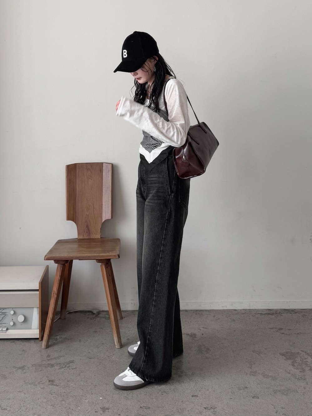 ホワイト系のTシャツ/カットソー、ブラック系のデニムパンツ、ブラウン系のボストンバッグを着用したレディースの冬コーディネートの3枚目の写真