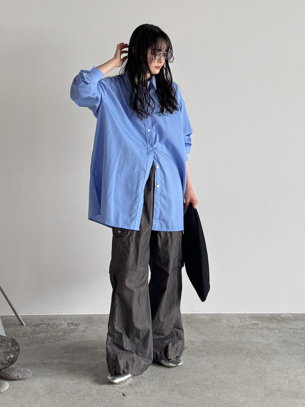 ブルー系のシャツ/ブラウス、グレー系のカーゴパンツ、ブラック系のハンドバッグを着用したレディースの春コーディネートの2枚目の写真