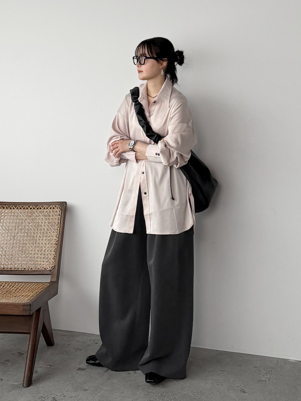 ピンク系のシャツ/ブラウス、グレー系のスラックス、ブラック系のショルダーバッグを着用したレディースの春コーディネートの2枚目の写真