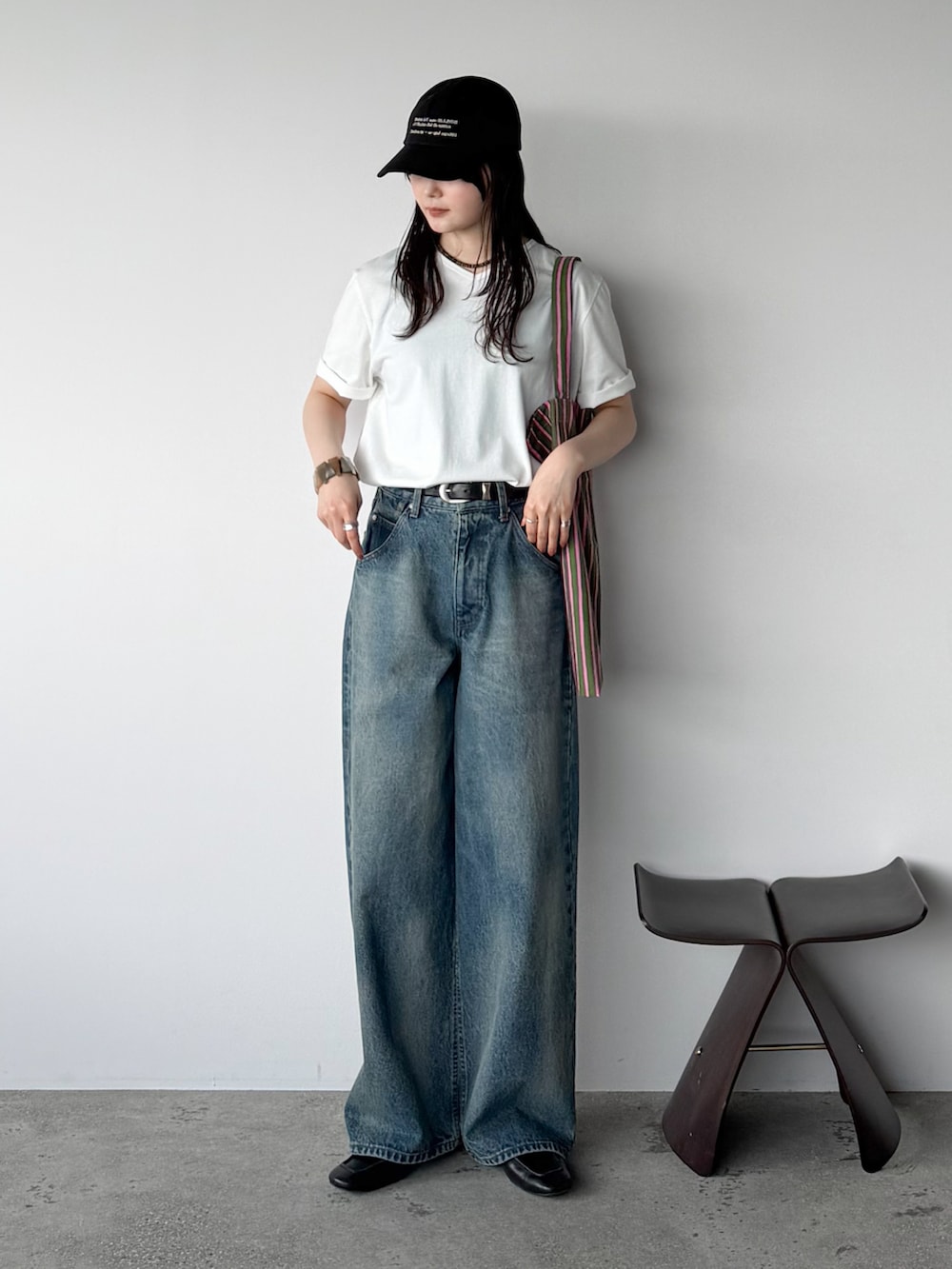 ホワイト系のTシャツ/カットソー、ブルー系のデニムパンツ、グリーン系のトートバッグを着用したレディースの夏コーディネートの2枚目の写真
