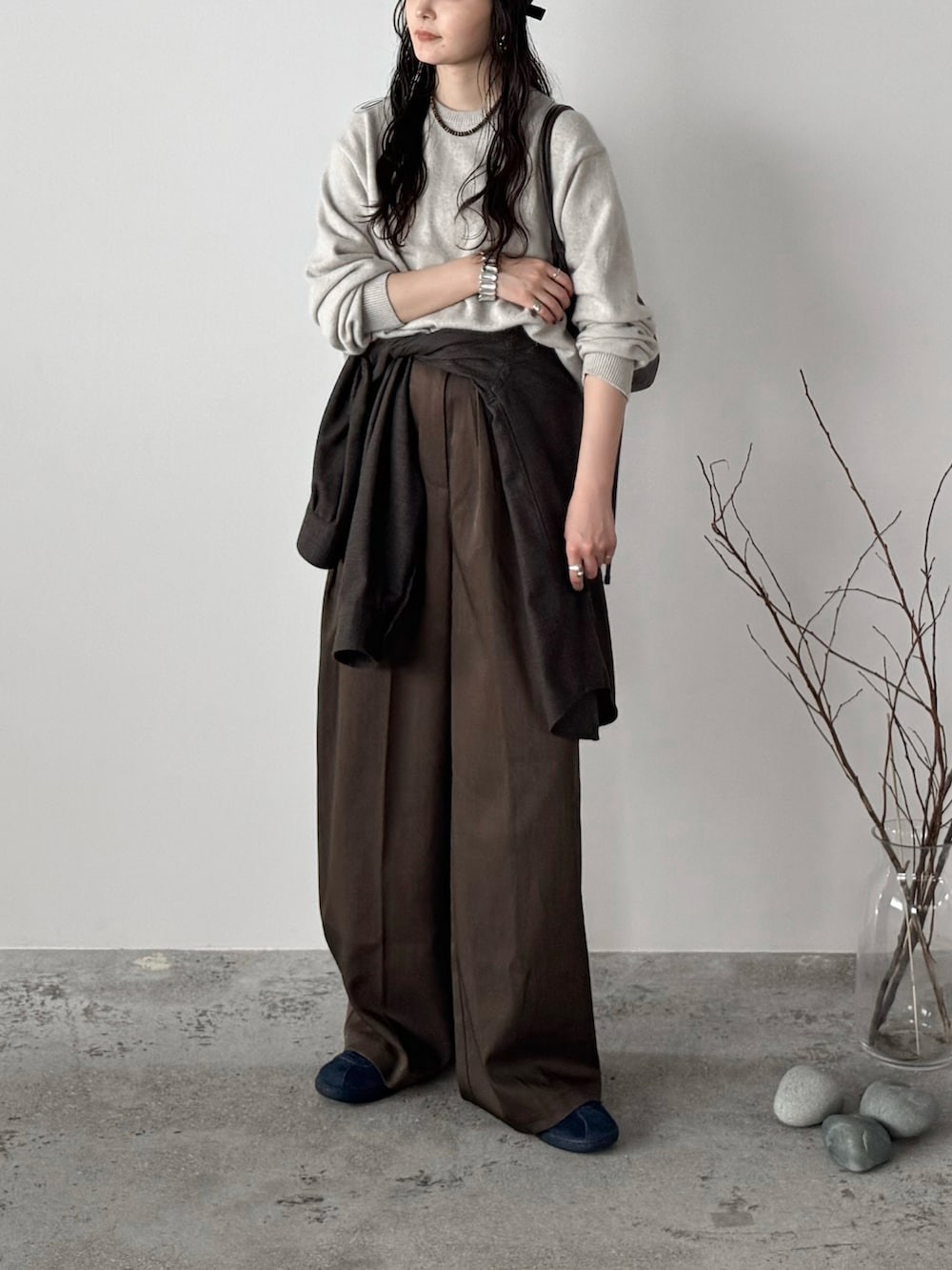 ブルー系のスニーカー、ブラウン系のスラックス、ホワイト系のニット/セーターを着用したレディースの秋コーディネートの2枚目の写真