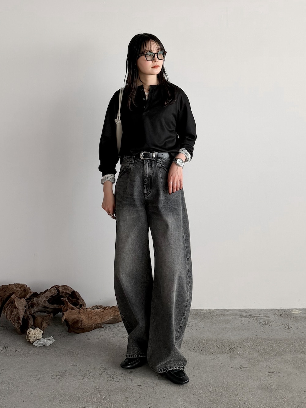 ブラック系のTシャツ/カットソー、グレー系のデニムパンツ、グレー系のショルダーバッグを着用したレディースの冬コーディネートの2枚目の写真