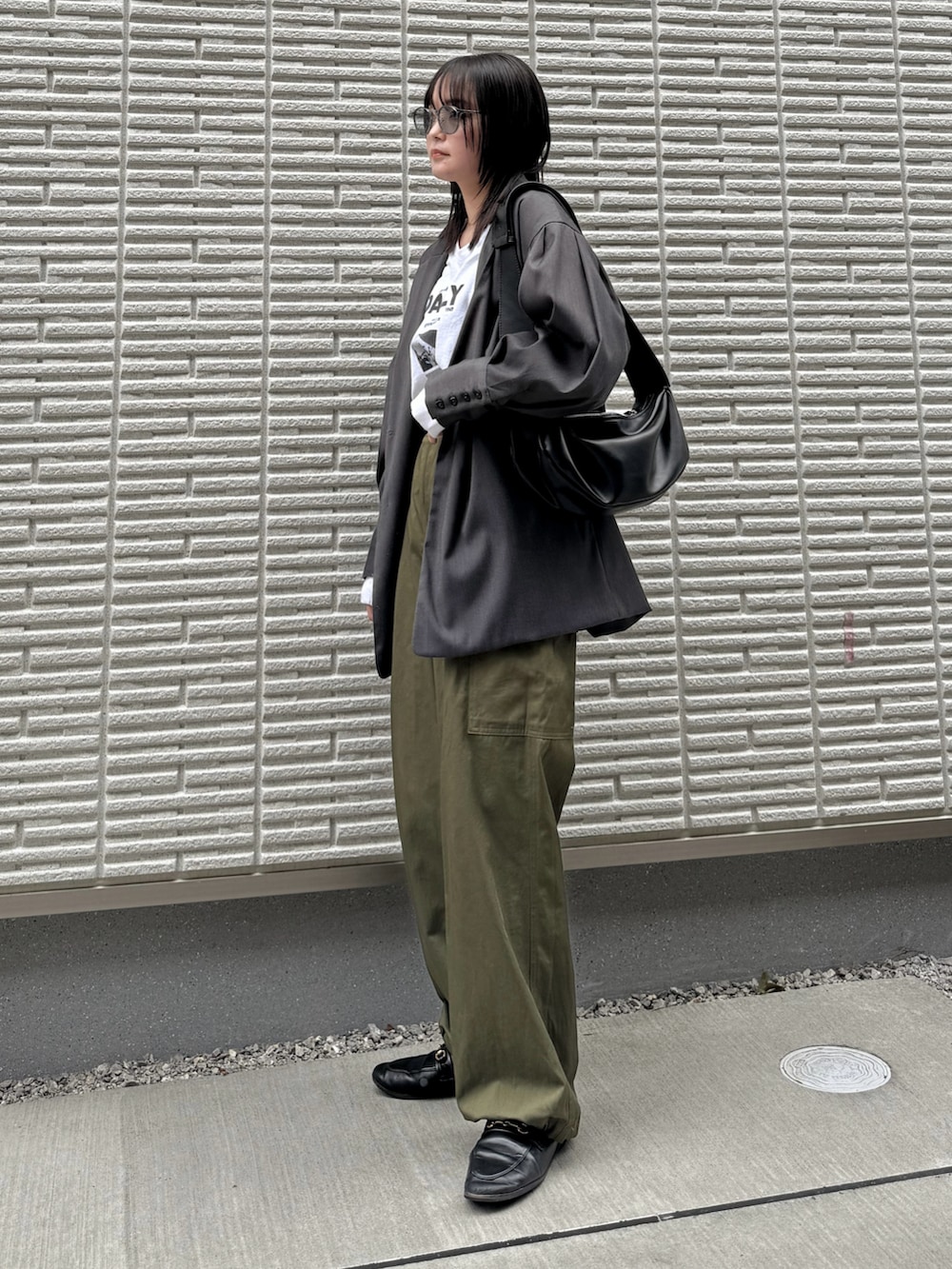 グレー系のテーラードジャケット、ホワイト系のTシャツ/カットソー、グリーン系のパンツを着用したレディースの冬コーディネートの2枚目の写真