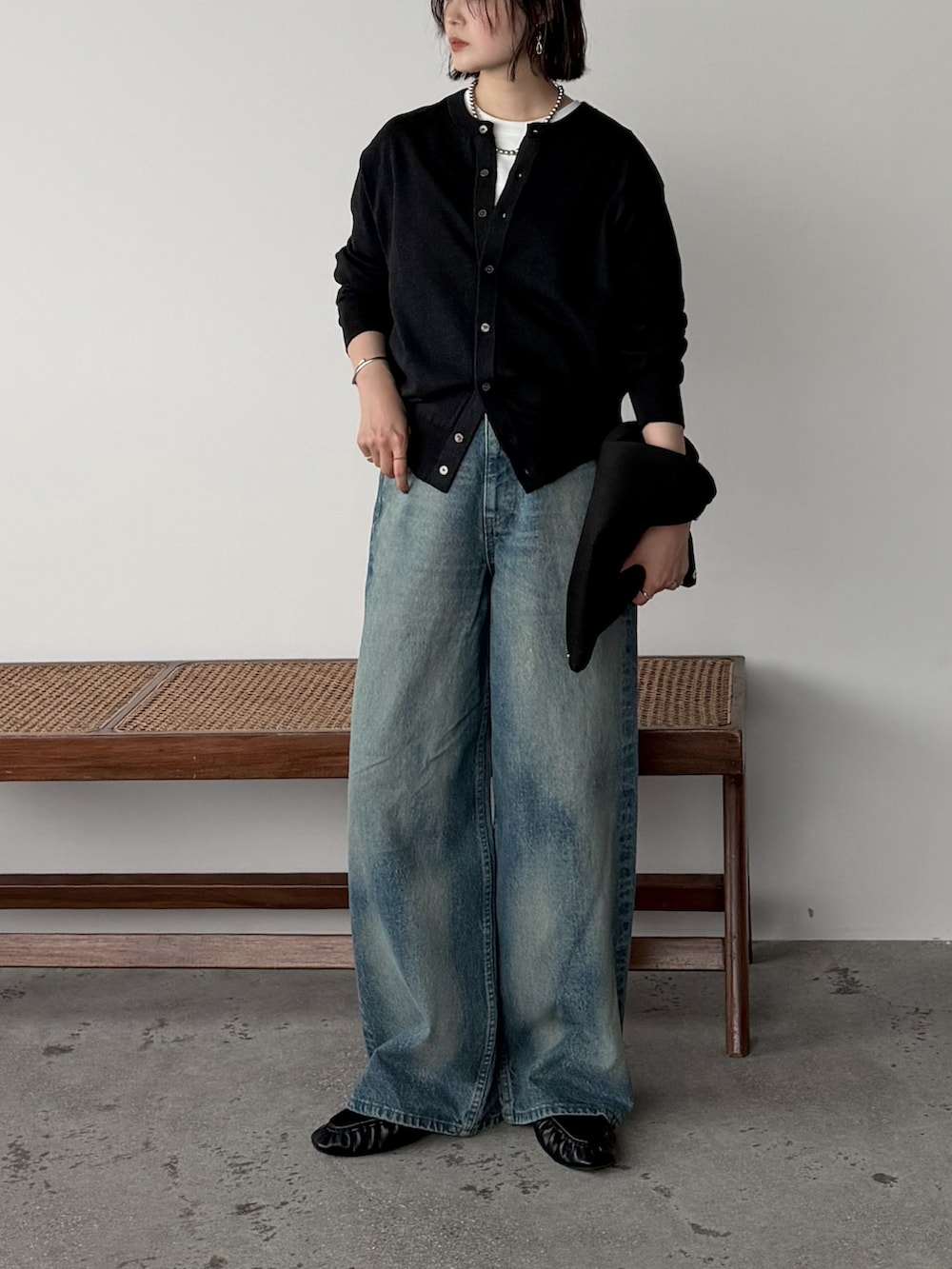 グレー系のカーディガン/ボレロ、ホワイト系のTシャツ/カットソー、ブルー系のデニムパンツを着用したレディースの秋コーディネートの2枚目の写真