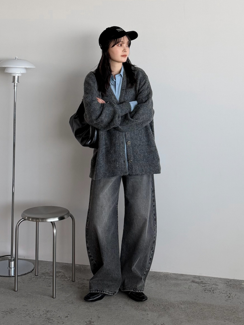 グレー系のカーディガン/ボレロ、ブルー系のシャツ/ブラウス、グレー系のデニムパンツを着用したレディースの冬コーディネートの2枚目の写真