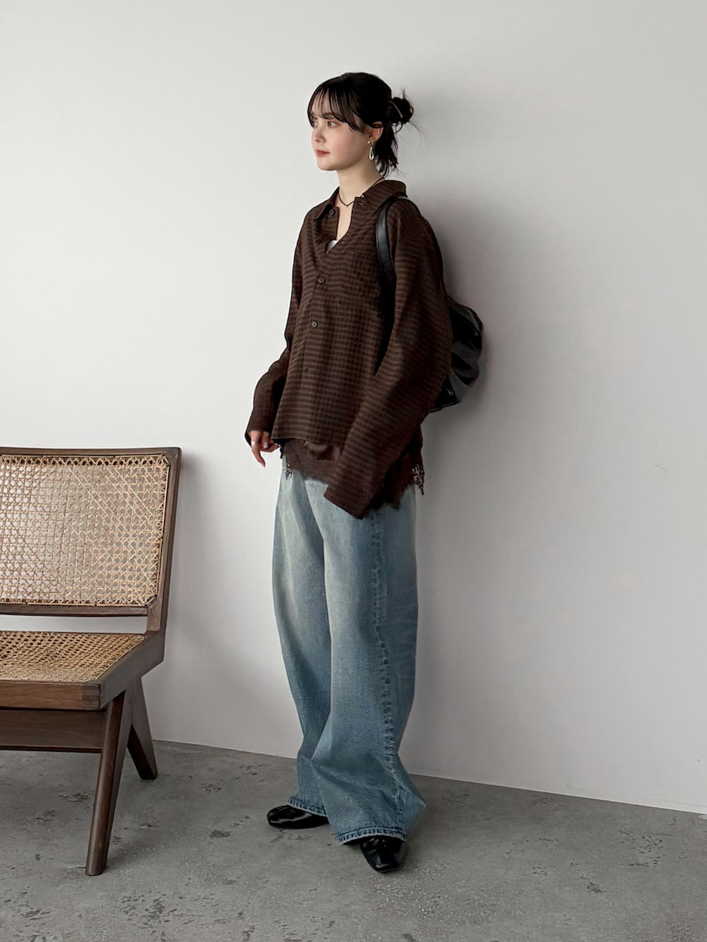 ブラウン系のシャツ/ブラウス、ブラウン系のキャミソール、ブルー系のデニムパンツを着用したレディースの春コーディネートの2枚目の写真