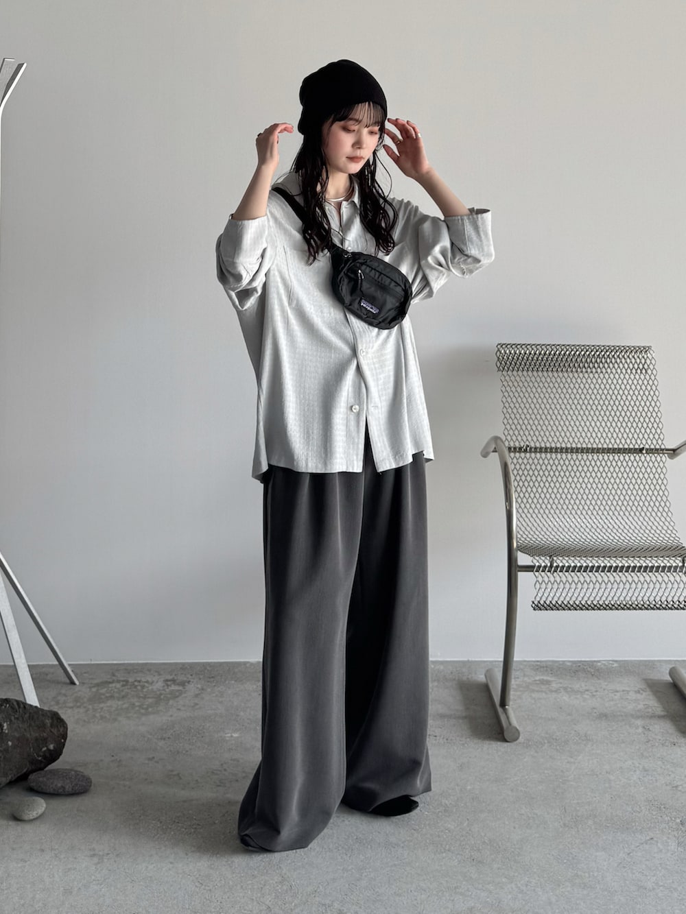 グレー系のシャツ/ブラウス、グレー系のスラックス、ブラック系のパンプスを着用したレディースの春コーディネートの2枚目の写真