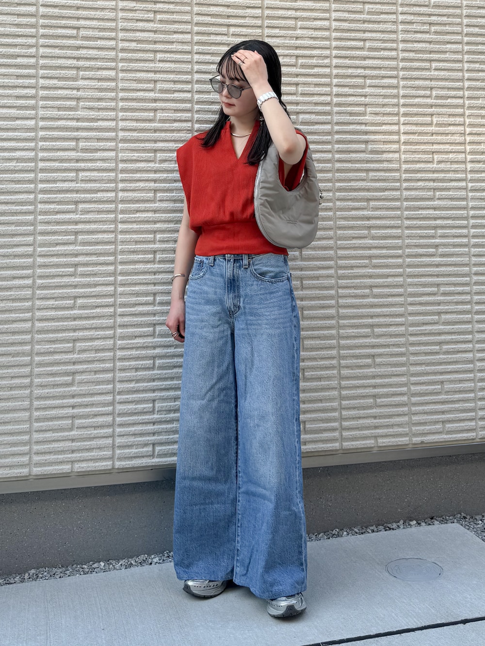 オレンジ系のTシャツ/カットソー、ブルー系のデニムパンツ、グレー系のハンドバッグを着用したレディースの夏コーディネートの2枚目の写真