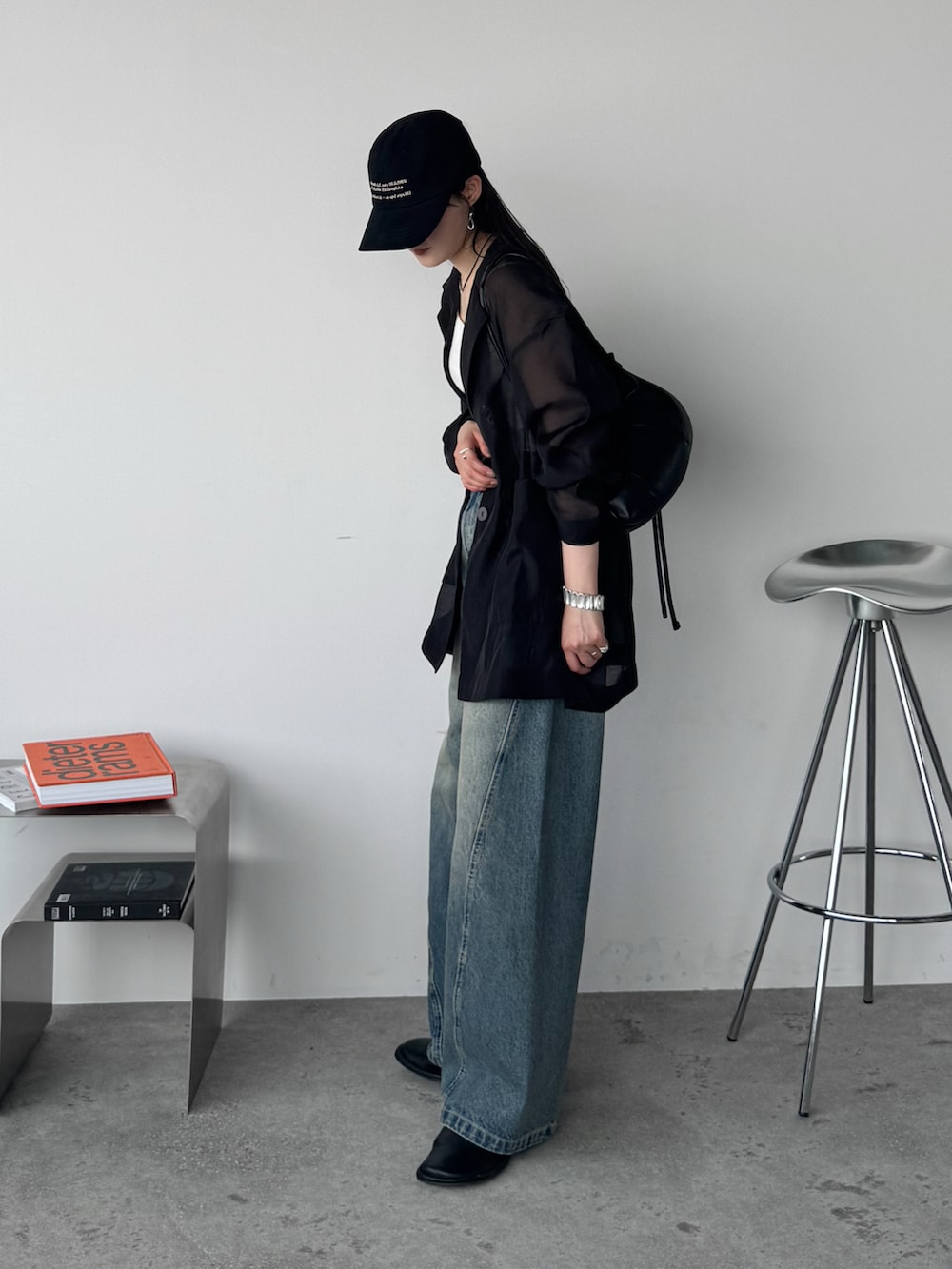 ブラック系のテーラードジャケット、ブルー系のデニムパンツ、ブラック系のショルダーバッグを着用したレディースの夏コーディネートの2枚目の写真