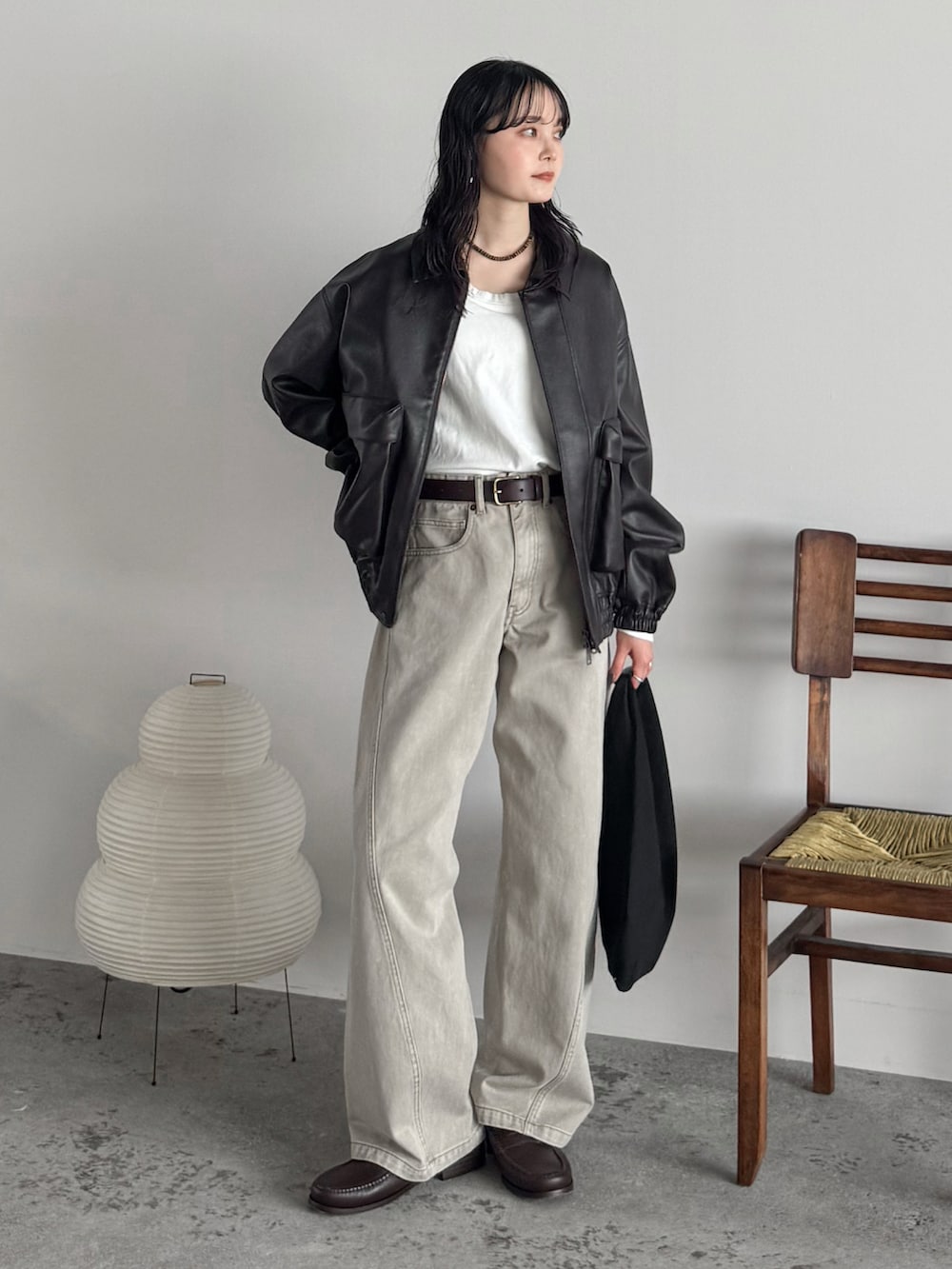 ホワイト系のTシャツ/カットソー、ブラウン系のブルゾン、ベージュ系のデニムパンツを着用したレディースの秋コーディネートの2枚目の写真