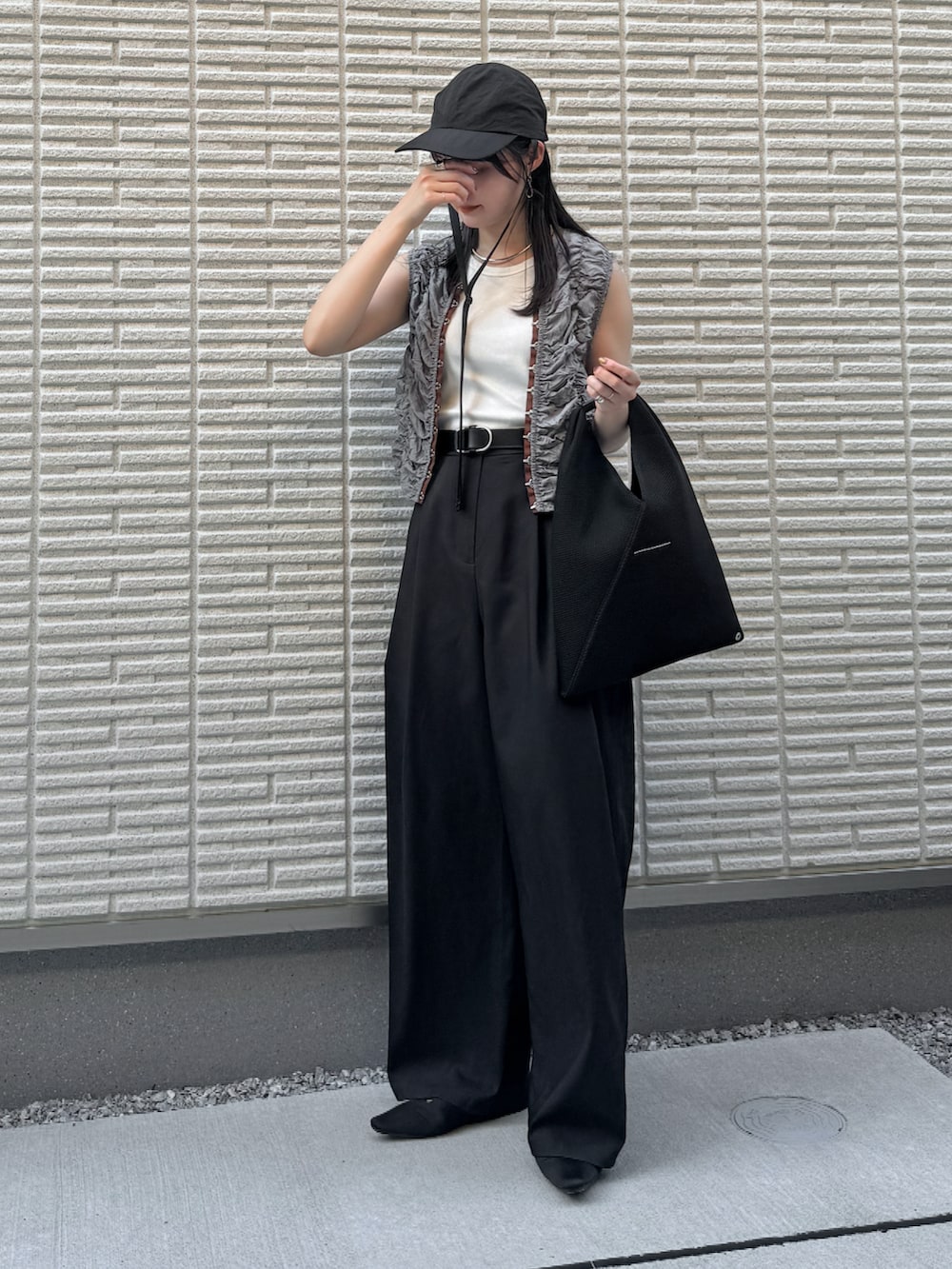 ブルー系のシャツ/ブラウス、ブラック系のスラックス、ブラック系のハンドバッグを着用したレディースの夏コーディネートの2枚目の写真