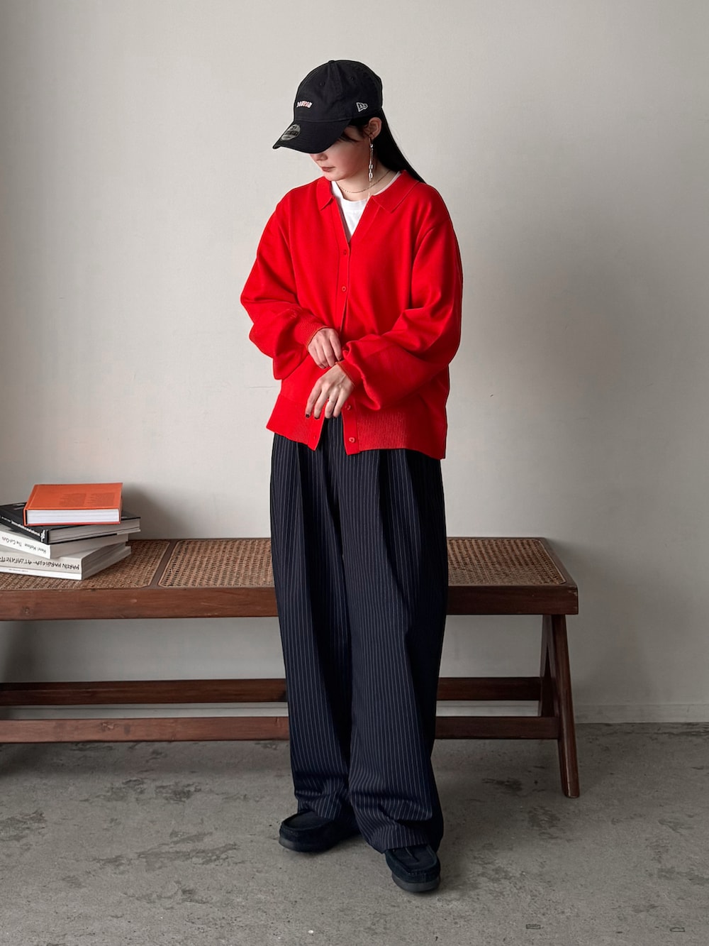 レッド系のカーディガン/ボレロ、グレー系のチェスターコート、ブルー系のスラックスを着用したレディースの冬コーディネートの3枚目の写真