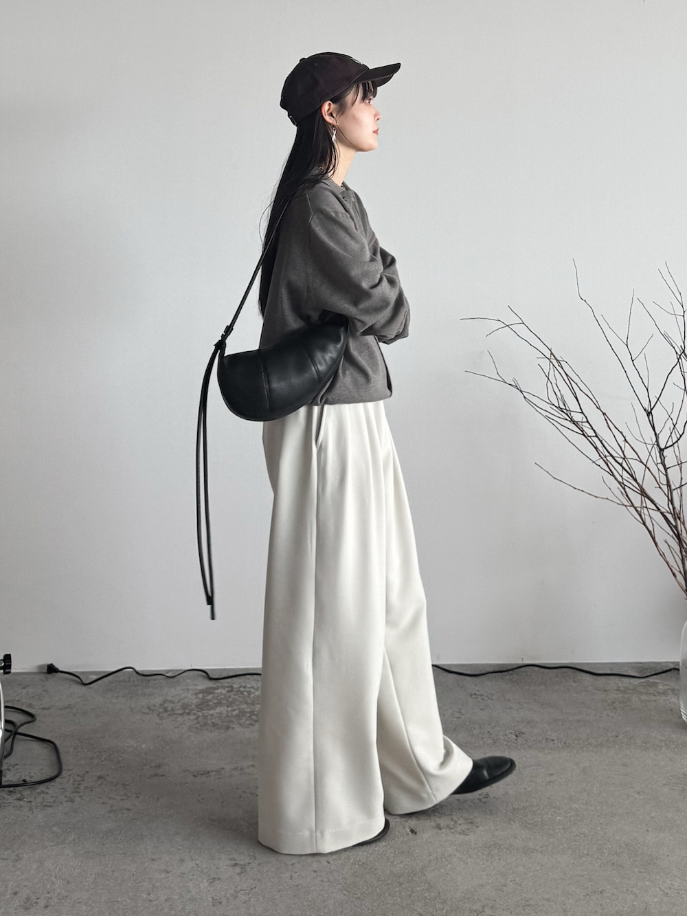 ベージュ系のシャツ/ブラウス、ホワイト系のスラックス、ブラウン系のショルダーバッグを着用したレディースの夏コーディネートの2枚目の写真